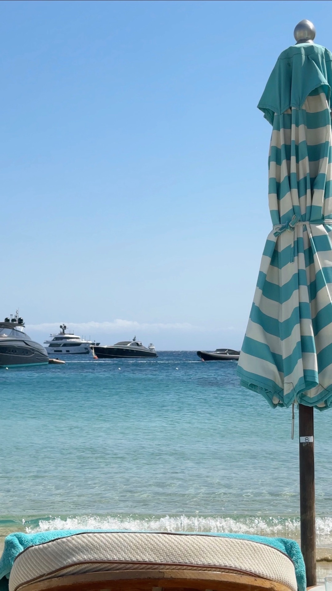 Beach club view with yachts anchored in the bay