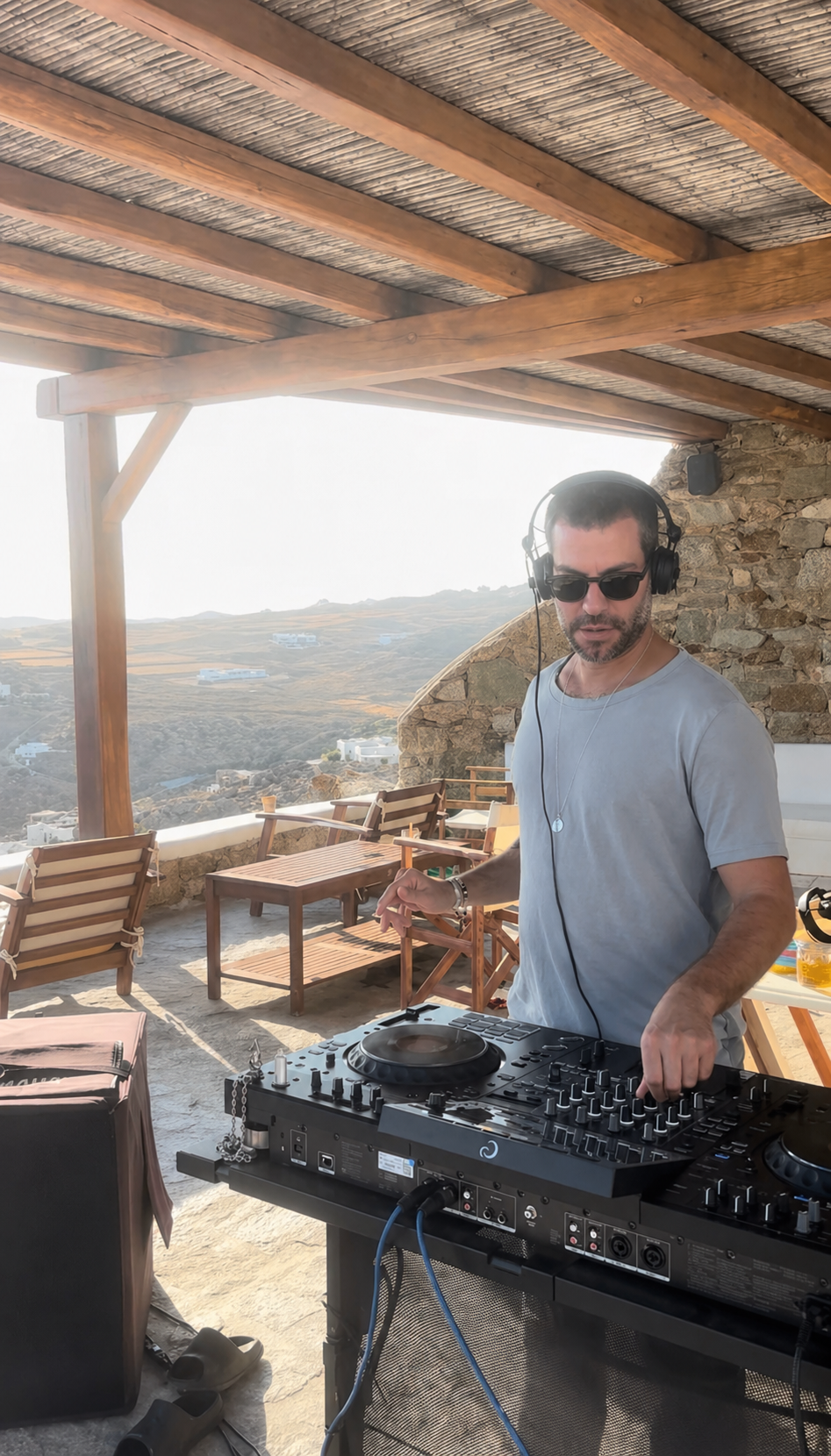Resident DJ playing at the Mykonos villa terrace at sunset